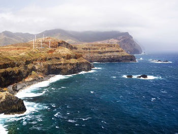 High angle view of rocky coastal feature against sky