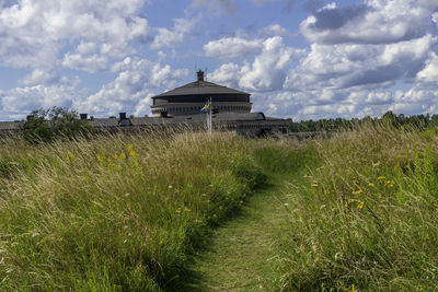 Built structure on field against sky