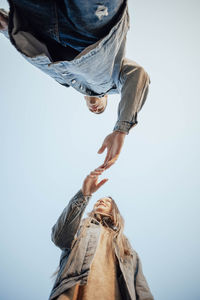 Hands of man and woman on blue sky background