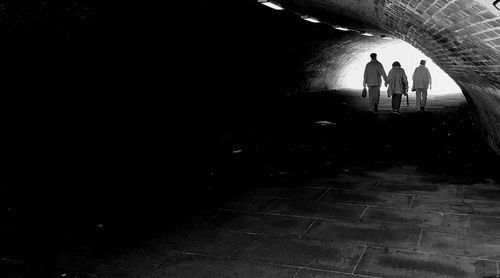 Silhouette people walking on footpath in city