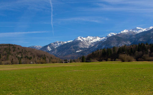 Scenic view of field and mountains against sky