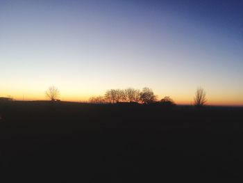 Silhouette trees against clear sky during sunset