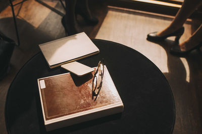 High angle view of diary with mobile phone and eyeglasses at table in office