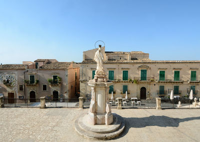 Statue of historic building against blue sky