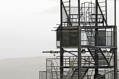 Low angle view of crane at construction site against sky