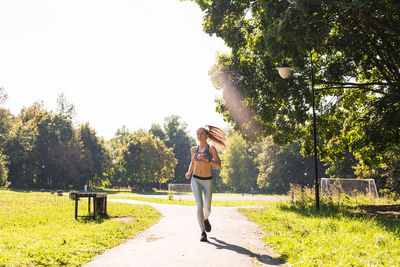 Woman standing by trees against plants