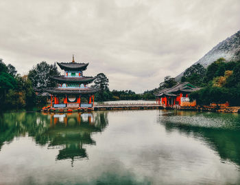 Reflection of building in lake against cloudy sky