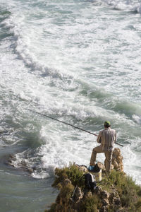 High angle view of man fishing in sea