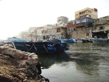 Boats moored on river against clear sky