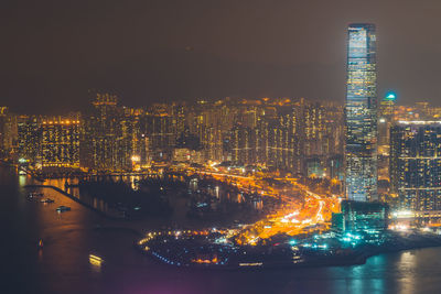 Illuminated buildings at victoria harbour in city during night