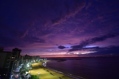 Panoramic view of illuminated city against sky at sunset