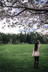 Rear view of woman standing on field