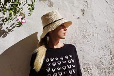 Young woman standing against wall