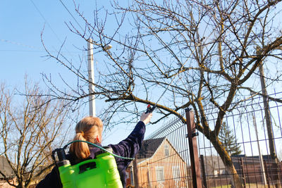 Fumigating pesti, pest control. defocus farmer woman spraying tree with manual pesticide sprayer 