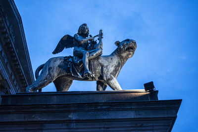 Low angle view of statue against blue sky