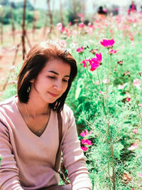 Portrait of young woman standing amidst plants