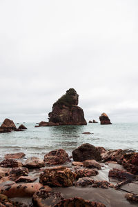 Rocks on beach against sky