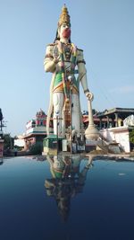 Statue on water against clear sky