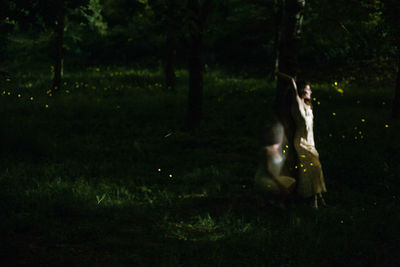 Woman on field by trees at night