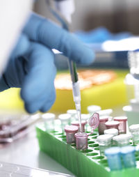 Cropped hand of scientist pipetting sample into eppendorf vials in laboratory