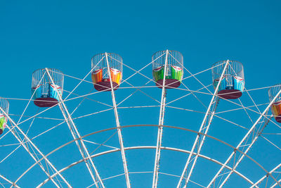 Low angle view of ferris wheel against blue sky