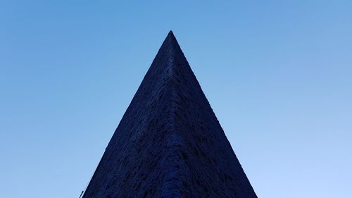 Low angle view of communications tower against blue sky
