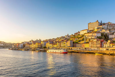 Scenic view of the city of porto in portugal in warm sunset light with douro river in foreground