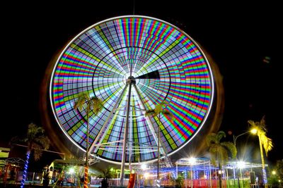 Low angle view of illuminated ferris wheel against sky at night