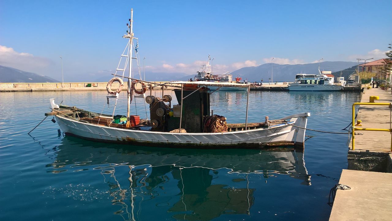 nautical vessel, transportation, mode of transportation, water, sky, moored, nature, built structure, day, sea, architecture, sunlight, no people, blue, harbor, waterfront, building exterior, outdoors, travel, sailboat, fishing boat, port, anchored, marina