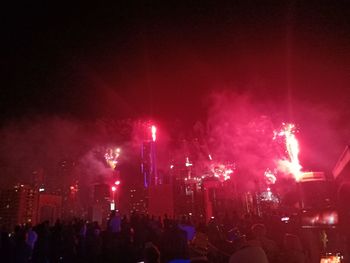 Crowd at music concert against sky at night