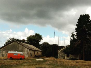 Houses by building against sky