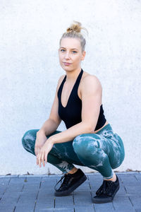 Portrait of young woman standing against white background