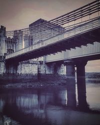 Low angle view of bridge over river against sky