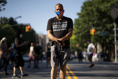 Full length of man standing on road in city