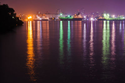 Scenic view of illuminated sea against sky at night