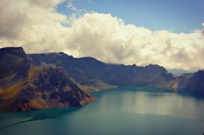 Scenic view of sea and mountains against sky