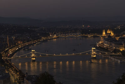 Illuminated bridge over river in budapest at night