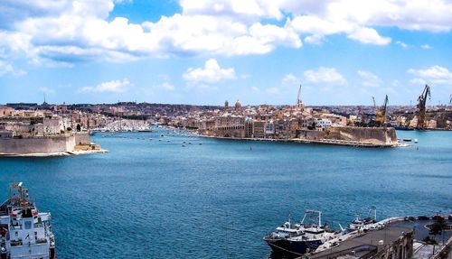 Panoramic view of buildings by sea against sky