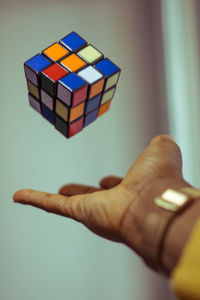 Close-up of hand holding toy over white background