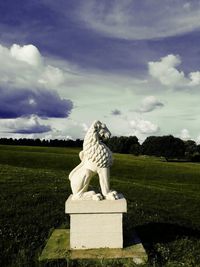 Close-up of statue on field against sky