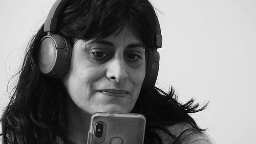 Close-up portrait of young woman using smart phone