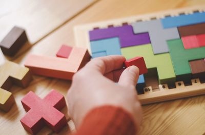 Close-up of hand holding multi colored pencils