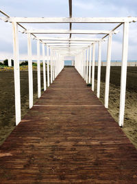 View of wooden bridge leading towards sea