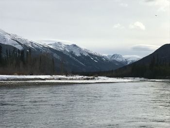 Scenic view of snowcapped mountains and sea against sky