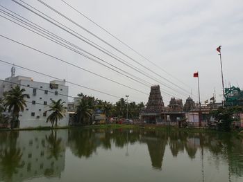 Reflection of trees and buildings in lake against sky