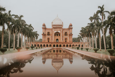 Exterior of safdarjungs tomb sandstone and marble mausoleum in new delhi reflecting in water of fountain