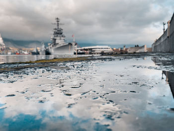 View of buildings by sea against cloudy sky