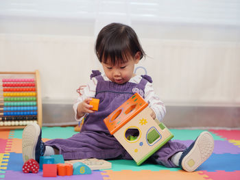 Baby girl playing with toys at home