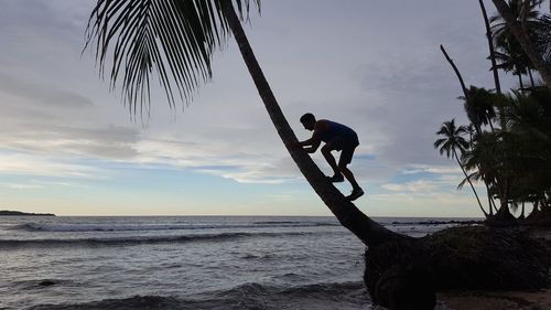 Silhouette man on beach against sky