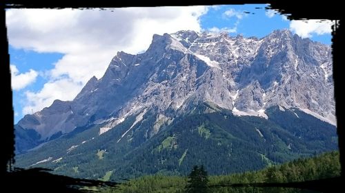 Scenic view of mountains against cloudy sky